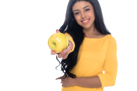 close-up view of beautiful happy young african american woman holding fresh apple and smiling at camera isolated on whiteの写真素材