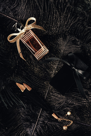 top view of perfume bottles with ribbons and decorative glittering feathersの写真素材