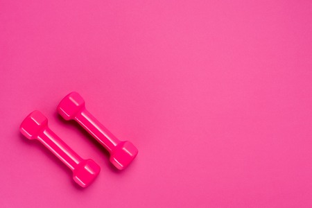 top shot of two dumbbells on pink background with copy spaceの写真素材