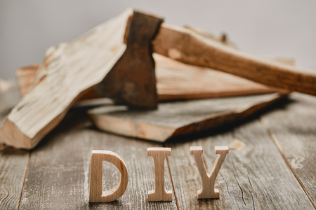 Close up of diy sign on wooden table on the background of logs and axeの写真素材
