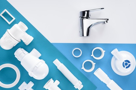 top view of plastic plumbing pieces and water mixer isolated on whiteの写真素材