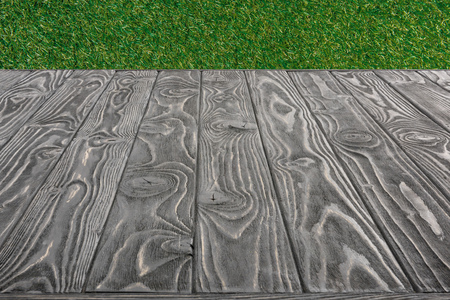 surface of grey wooden planks on green grass backgroundの写真素材