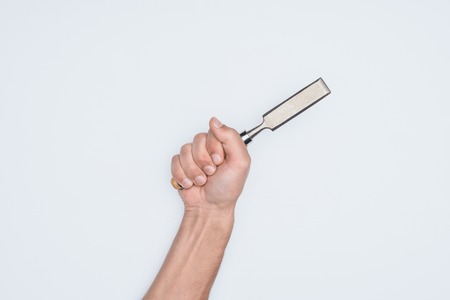 cropped shot of man holding chisel isolated on whiteの写真素材