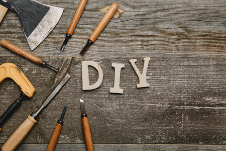 Top view of different carpentry tools and diy sign on wooden backgroundの写真素材
