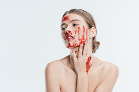nude wounded adult woman with blood on skin isolated on whiteの写真素材