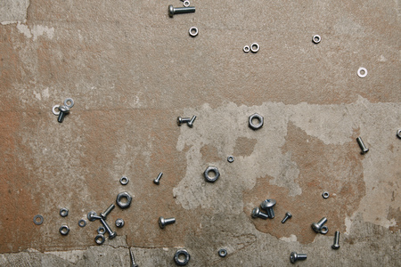 Top view of screws and bolts scattered on the background of old  surface