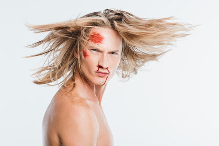 adult man with bloody bruises on face waving hair isolated on whiteの写真素材