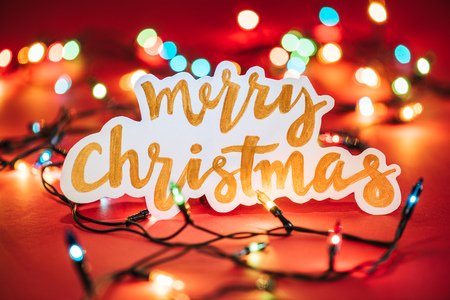 Merry Christmas sign on the background of shining garlandsの写真素材