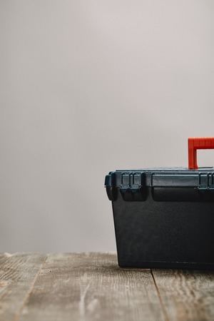 Close up of tools box on wooden table on grey background