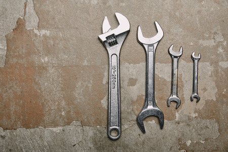 Top view of set of wrenches tools and one monkey wrench on the background of old  surfaceの写真素材