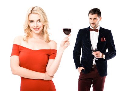 Couple of smiling blonde woman and serious man with glasses of wine isolated on whiteの写真素材