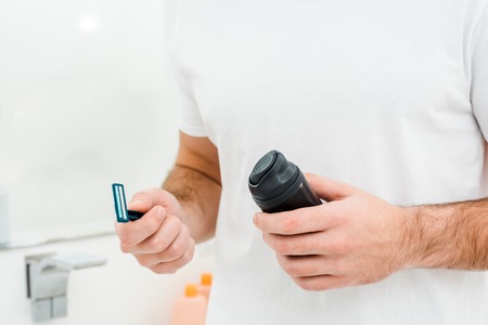 Man holding in hands safety razor and shaving foamの写真素材