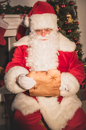 santa claus holding parchment and reading wish listの写真素材