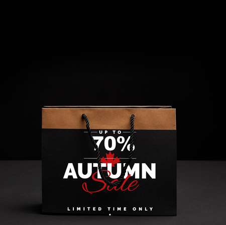 paper shopping bag on black backdrop with autumn sale and 70 percents discount