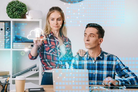 businessman looking at female colleague pointing at cyber security sign at workplace in office, web...