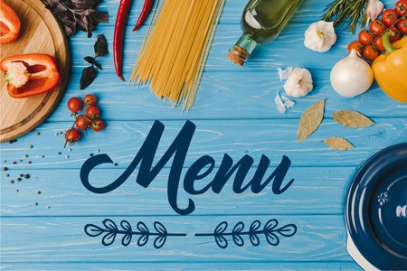 top view of ingredients for cooking pasta on blue table, menu letteringの写真素材