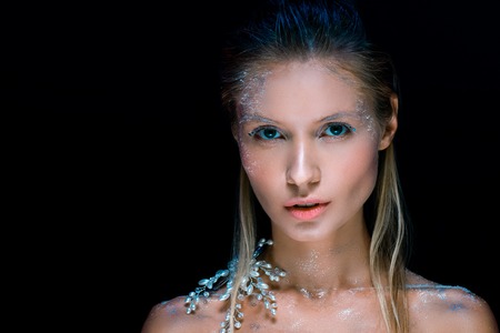 Beautiful snow queen looking at camera isolated on black
