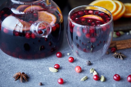 delicious homemade mulled wine with cranberries on table in kitchenの写真素材