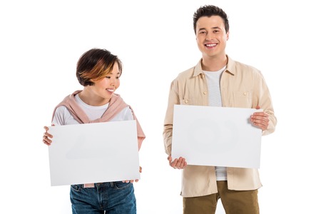 cheerful husband and wife looking at camera and holding two blank boards isolated on white