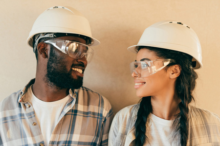 happy african american couple in protective helmets and gogges looking at each other