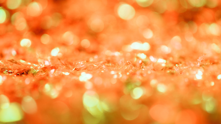 abstract glowing background with orange glitter and bokeh