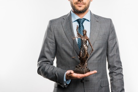 mid section of lawyer holding lady justice statue isolated on whiteの写真素材
