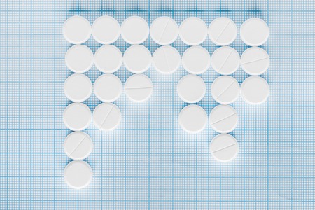 elevated view of arranged white pills on blue checkered surfaceの写真素材