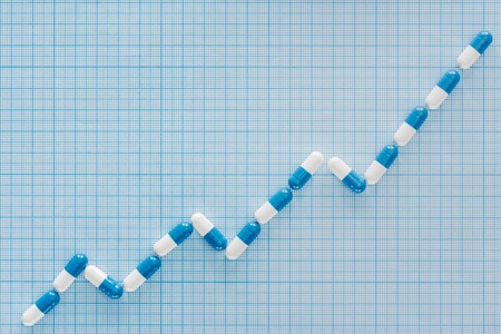 flat lay with pills graph on blue checkered surface