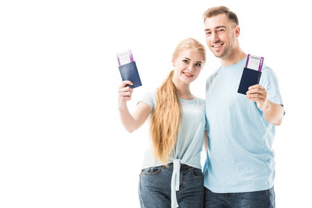 Couple smiling and holding passports with tickets isolated on whiteの写真素材
