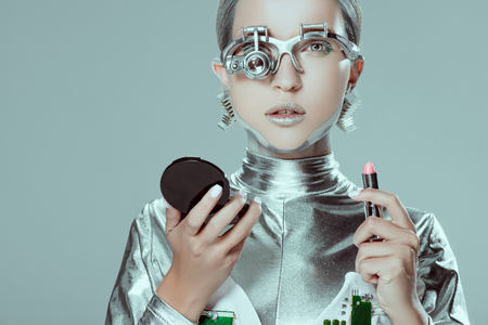 silver robot holding mirror and lipstick isolated on grey, future technology conceptの写真素材