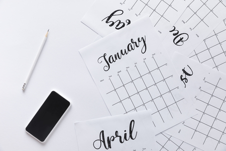 flat lay with calendar, smartphone and pencil isolated on whiteの写真素材