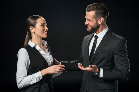 cheerful businesspeople discussing work, isolated on blackの写真素材