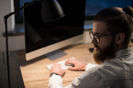 businessman typing something on keyboard in office and looking awayの写真素材