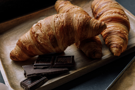 close up view of chocolate and croissants on wooden trayの写真素材