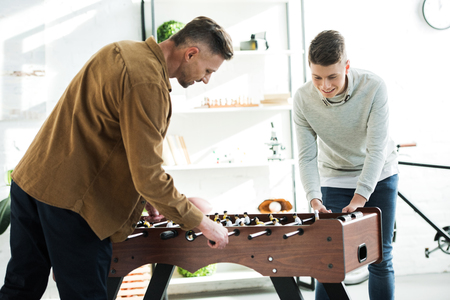 father and son playing table soccer at homeの写真素材