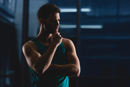 silhouette of thoughtful muscular sportsman in gymの写真素材