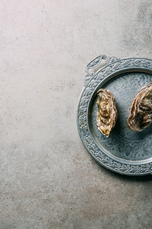 top view of oysters on metal tray on grey tabletopの写真素材