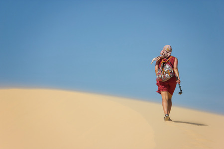 rear view of lonely woman with backpack walking in desert, Vietnam, Phan Thietの写真素材