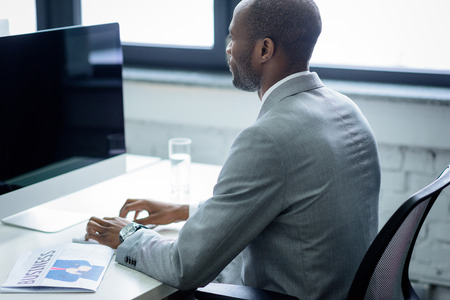 Side view of African american man working on computer in officeの写真素材