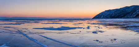 beautiful scenic landscape with shore and frozen lake Baikal at sunsetの写真素材