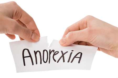 Cropped shot of woman tearing paper with anorexia inscription isolated on whiteの写真素材