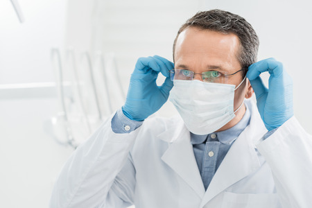 Doctor wearing medical mask in modern dental clinicの写真素材
