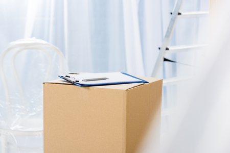 clipboard with pen on box in empty roomの写真素材