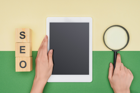 Top view of female seo manager holding digital tablet and magnifierの写真素材
