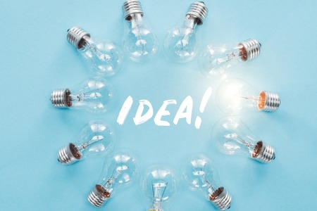 circle of light bulbs with glowing one surronding 'idea' word, having new ideas conceptの写真素材