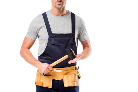 partial view of worker in overalls holding hammer isolated on whiteの写真素材