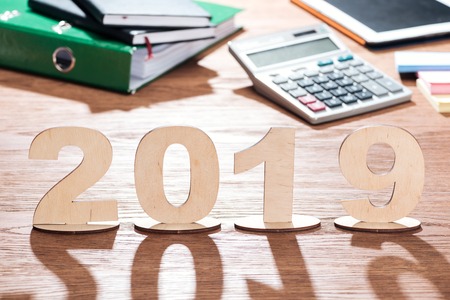2019 date made of plywood numbers with shadows on wooden office desk