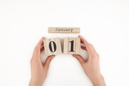 cropped view of woman holding wooden cubes with january 1st date isolated on whiteの写真素材