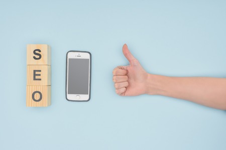 Top view of female seo manager putting thumbs up on light blue background