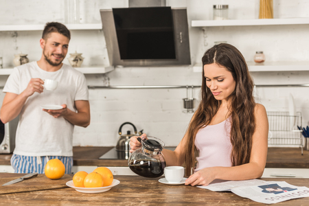 girlfriend and boyfriend drinking coffee in morning at kitchenの写真素材